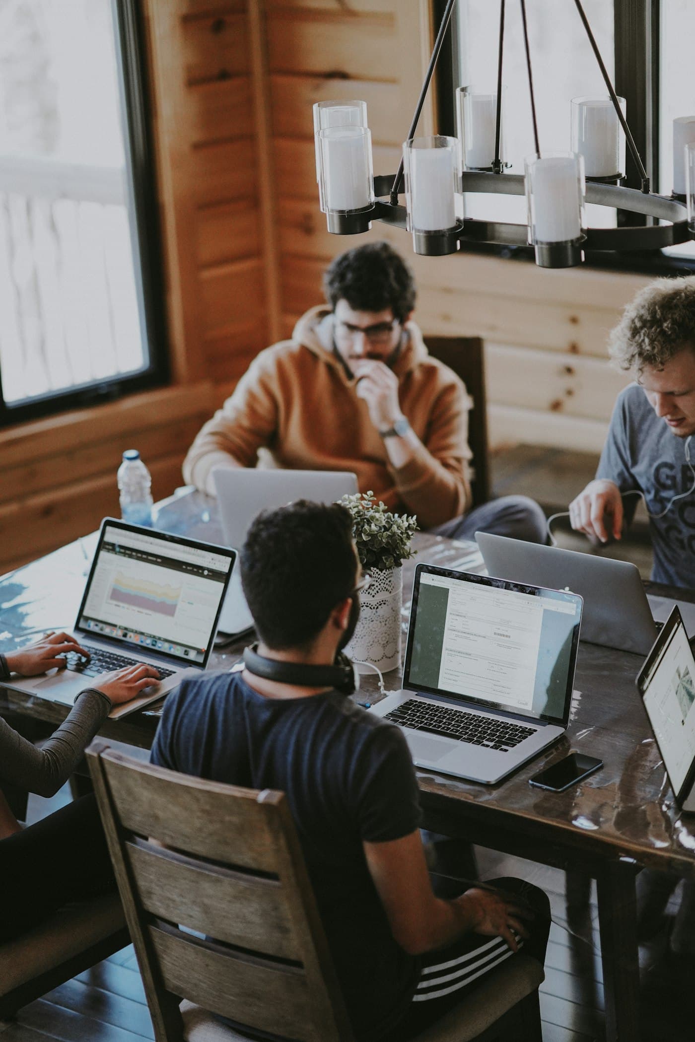 A team sitting around laptops and sticky notes in a bright workshop